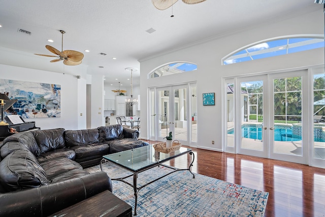 living area with french doors, ceiling fan with notable chandelier, and visible vents