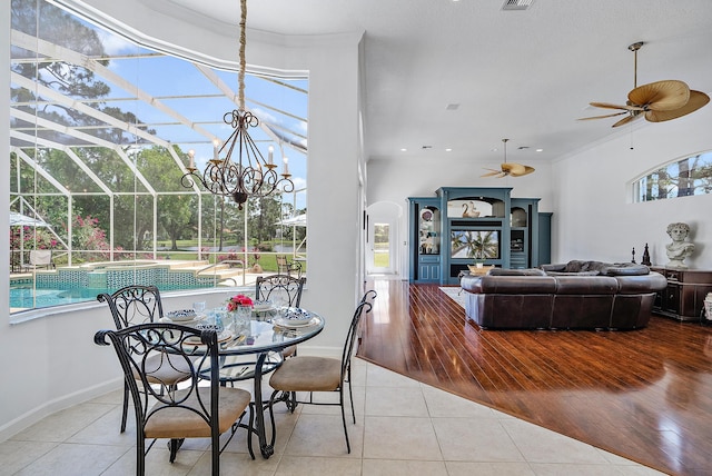 dining room with crown molding, a sunroom, a ceiling fan, visible vents, and tile patterned flooring