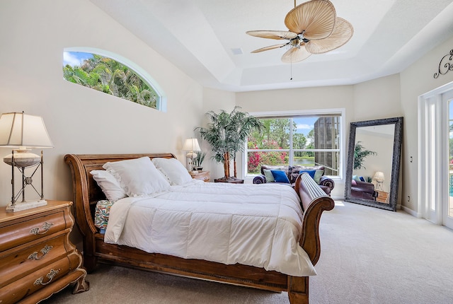 bedroom with visible vents, access to exterior, a tray ceiling, ceiling fan, and carpet