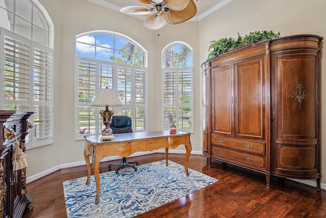 home office with dark wood-type flooring, baseboards, crown molding, and a ceiling fan