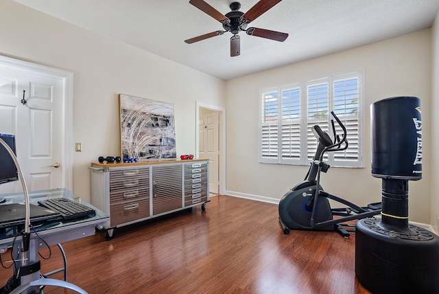 workout area featuring ceiling fan, baseboards, and wood finished floors