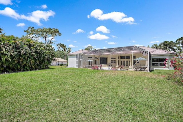 back of property featuring a yard, glass enclosure, and stucco siding