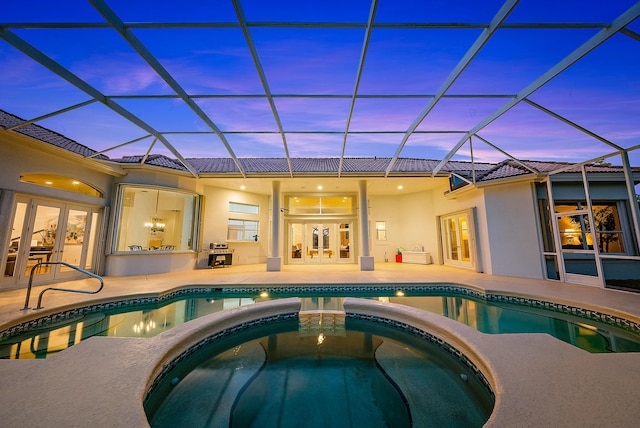 view of pool featuring a lanai, a patio, french doors, and a pool with connected hot tub