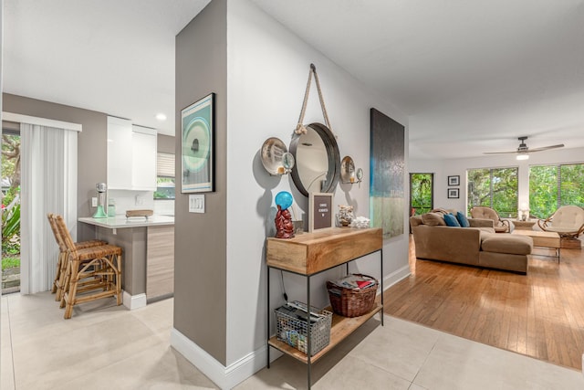 hallway with light tile patterned floors and baseboards