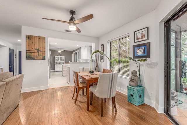 dining space with baseboards, visible vents, light wood-type flooring, and ceiling fan