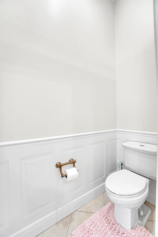 6298 Via Primo St, Lake Worth, FL 33467 - bathroom featuring tile patterned floors, toilet, a wainscoted wall, and a decorative wall