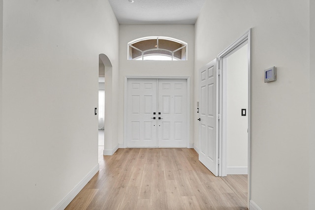 6298 Via Primo St, Lake Worth, FL 33467 - entryway with arched walkways, light wood-style flooring, baseboards, and a high ceiling