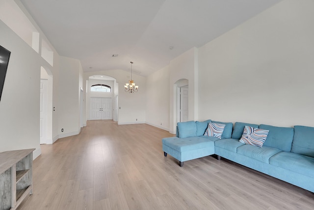 6298 Via Primo St, Lake Worth, FL 33467 - living room with arched walkways, vaulted ceiling, light wood finished floors, a chandelier, and baseboards