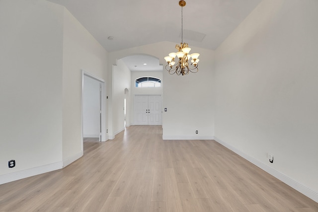 6298 Via Primo St, Lake Worth, FL 33467 - spare room featuring arched walkways, a chandelier, lofted ceiling, light wood-type flooring, and baseboards