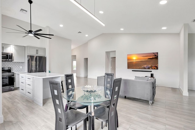 dining room with ceiling fan, recessed lighting, high vaulted ceiling, and baseboards