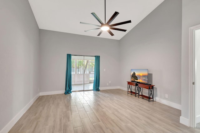 unfurnished room with high vaulted ceiling, ceiling fan, light wood-type flooring, and baseboards