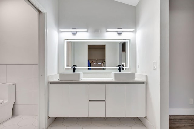 bathroom with double vanity and toilet