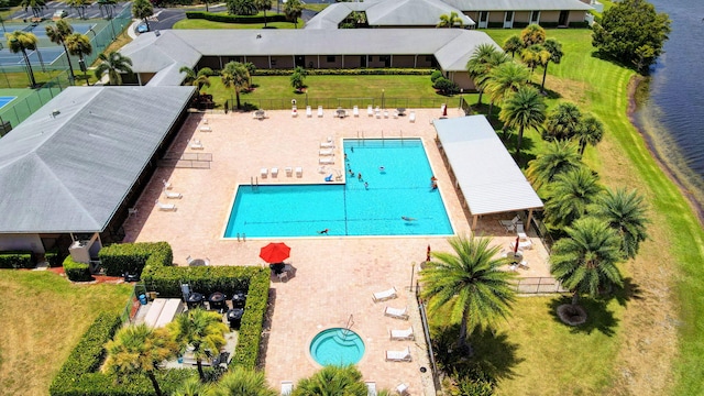 drone / aerial view of a pool area and a nearby body of water