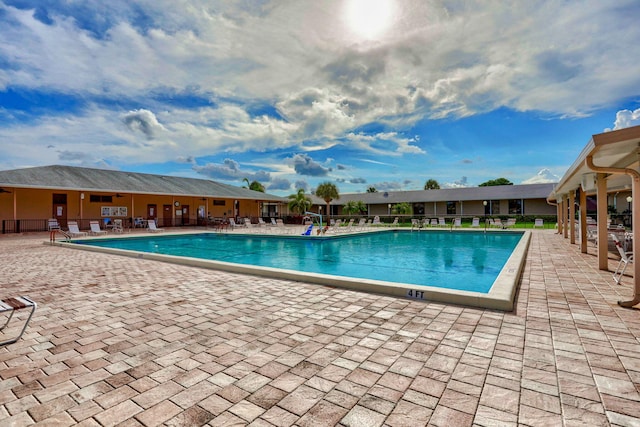 community pool featuring a patio area and fence