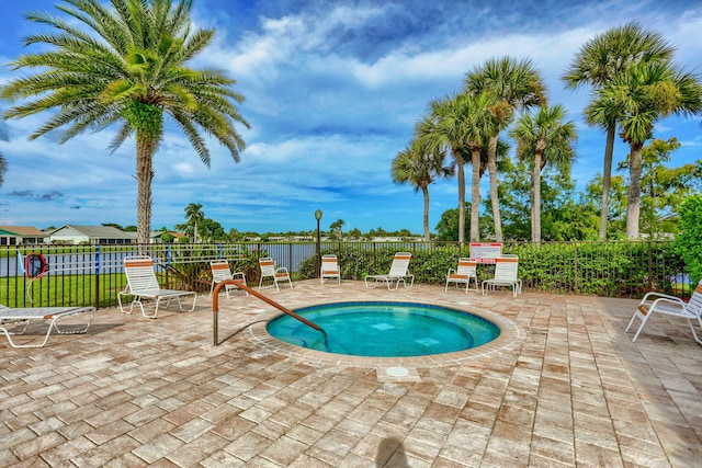 view of pool with fence, a patio area, and a hot tub