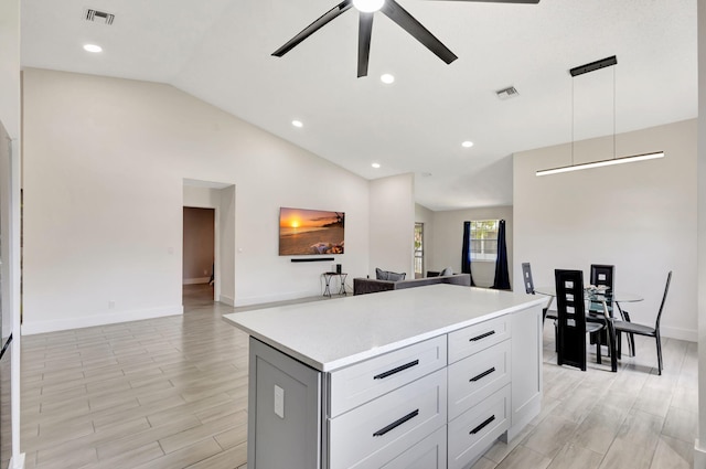 kitchen featuring open floor plan, ceiling fan, vaulted ceiling, light countertops, and baseboards