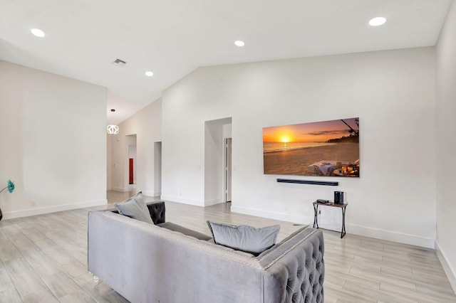 living area with lofted ceiling, baseboards, recessed lighting, and light wood-style floors
