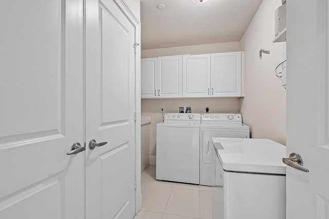 621 Bay Colony Drive S & Slip 13, Juno Beach, FL 33408 - laundry area featuring cabinet space, washing machine and dryer, light tile patterned floors, and a textured ceiling
