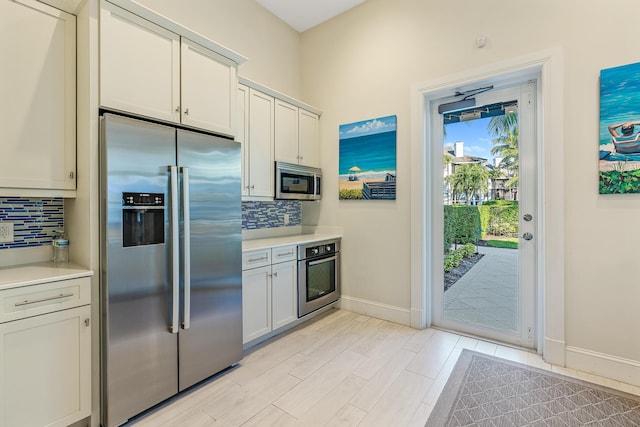 621 Bay Colony Drive S & Slip 13, Juno Beach, FL 33408 - kitchen featuring appliances with stainless steel finishes, light countertops, and decorative backsplash