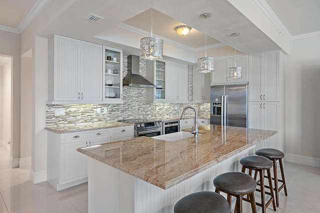 621 Bay Colony Drive S & Slip 13, Juno Beach, FL 33408 - kitchen with stainless steel appliances, wall chimney exhaust hood, light tile patterned floors, tasteful backsplash, and a breakfast bar area