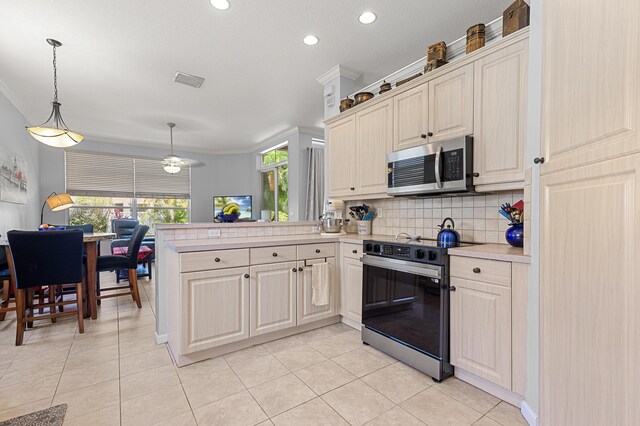 2111 Bellcrest Ct, Royal Palm Beach, FL 33411 - kitchen with stainless steel microwave, range with electric stovetop, light countertops, a peninsula, and backsplash