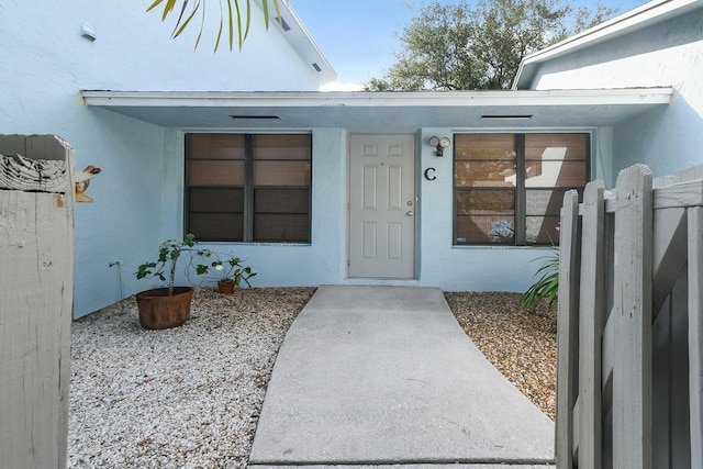 431 Jupiter Lakes Blvd Unit 2113C, Jupiter, FL 33458 - doorway to property featuring stucco siding and fence