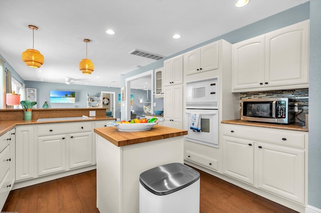 kitchen with white cabinets, light countertops, decorative backsplash, and white electric stovetop