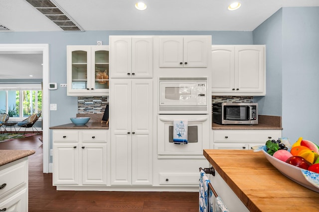 kitchen with a sink, white appliances, a peninsula, wood counters, and open floor plan