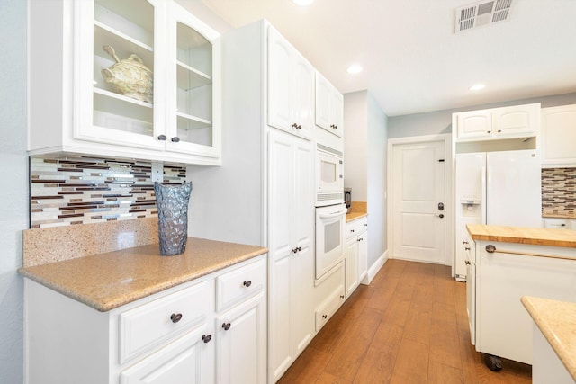 full bathroom with toilet, wood finished floors, a stall shower, vanity, and baseboards