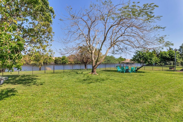view of yard featuring a water view and fence