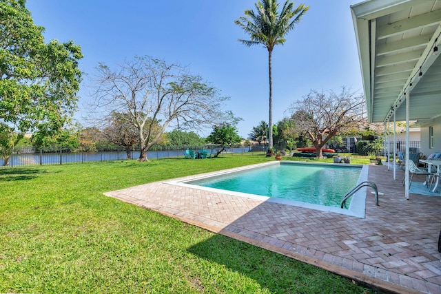 view of pool with a patio area, a lawn, a water view, a fenced backyard, and a fenced in pool