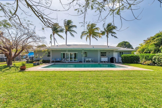 back of property featuring a lawn and a fenced in pool
