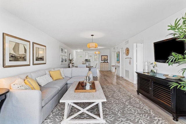 living room with visible vents and light wood-style flooring