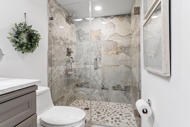 bathroom featuring vanity, a shower stall, and toilet