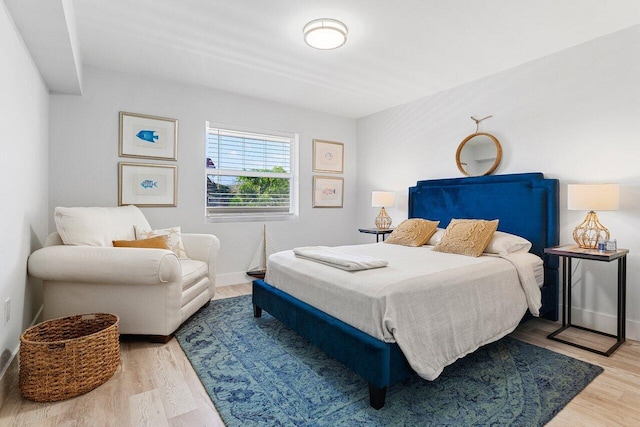 bedroom with baseboards and wood finished floors