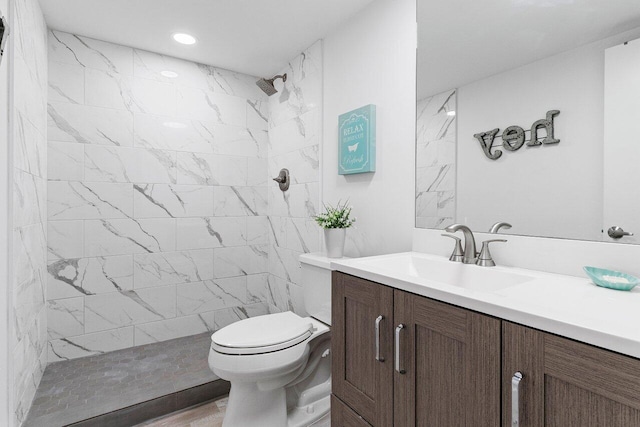 full bathroom with recessed lighting, vanity, toilet, and tiled shower