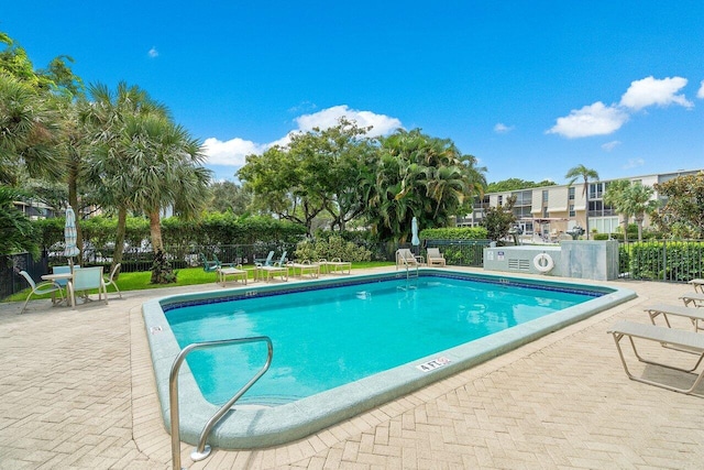 pool with a patio and fence