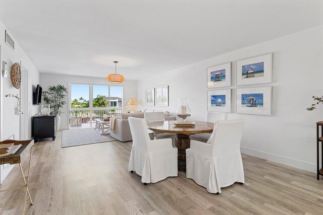 dining space featuring light wood-style floors, baseboards, and visible vents