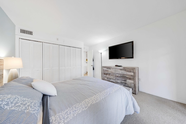 carpeted bedroom with a closet, visible vents, and baseboards