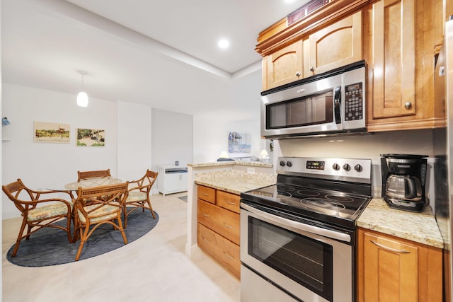 kitchen featuring hanging light fixtures, light stone counters, light tile patterned floors, stainless steel appliances, and a peninsula