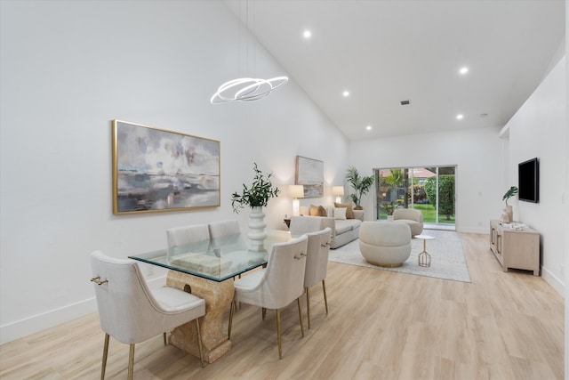 dining room with baseboards, recessed lighting, high vaulted ceiling, and light wood-style flooring