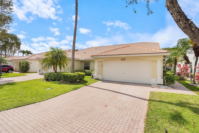 6092 Caladium Rd, Delray Beach, FL 33484 - mediterranean / spanish house with stucco siding, decorative driveway, an attached garage, a tile roof, and a front yard
