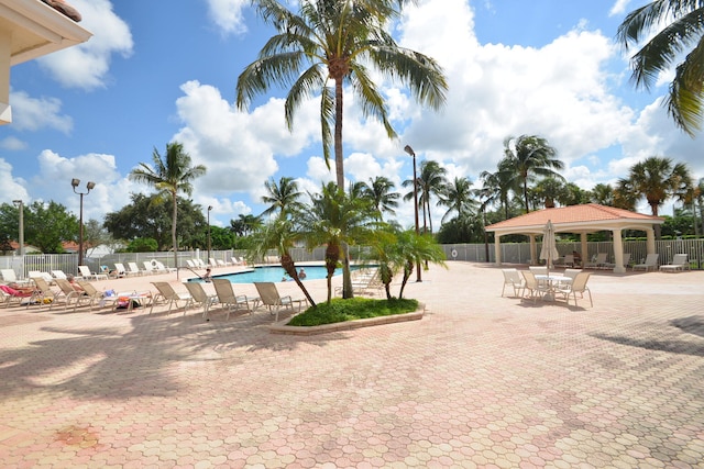 pool with a gazebo, fence, and a patio area