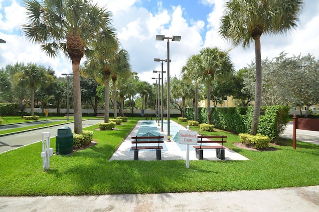view of community featuring shuffleboard and a lawn