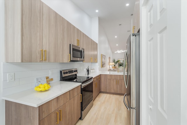 kitchen with backsplash, appliances with stainless steel finishes, modern cabinets, light stone countertops, and recessed lighting