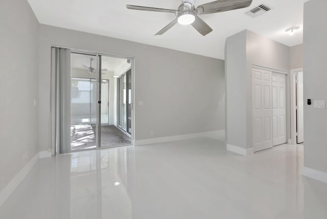empty room featuring baseboards, ceiling fan, and visible vents