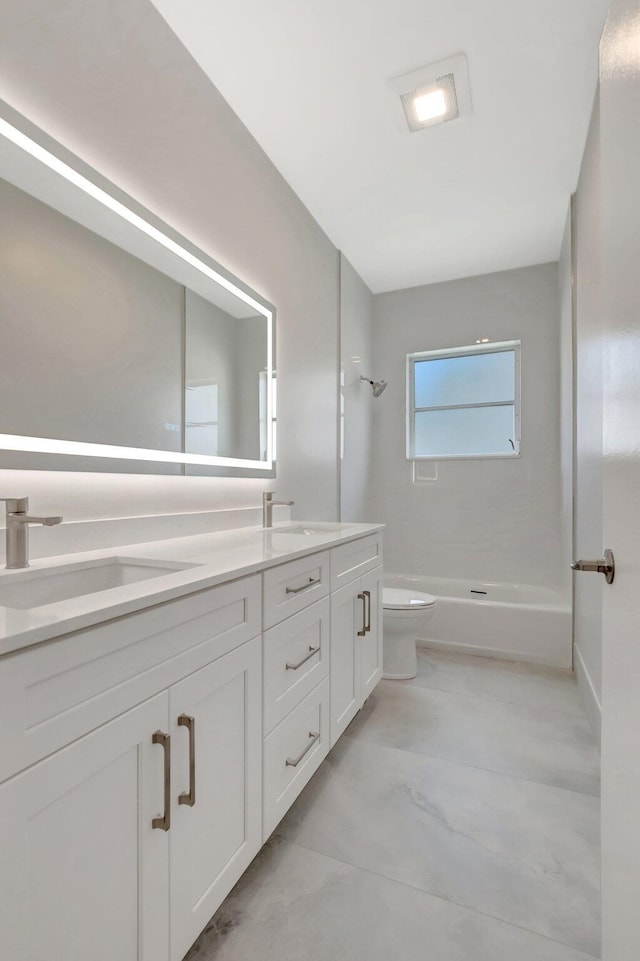 bathroom featuring double vanity, toilet, washtub / shower combination, and a sink