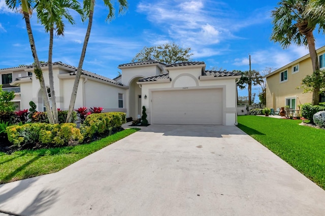 mediterranean / spanish-style house featuring a garage, stucco siding, a front yard, and concrete driveway