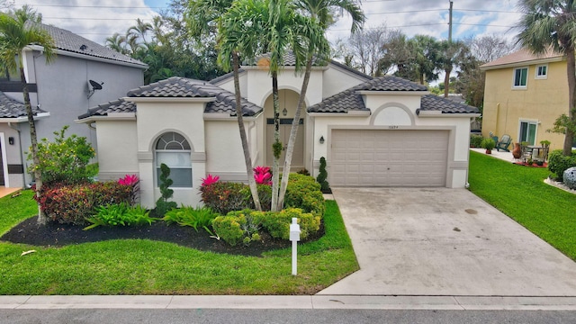 mediterranean / spanish home featuring a garage, a front lawn, a tiled roof, and driveway