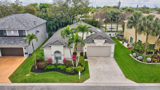 mediterranean / spanish home featuring an attached garage, a front lawn, stucco siding, and driveway